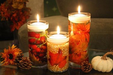 Fall floating candles with pumpkins and pine cones.
