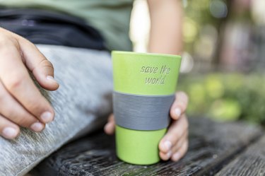 Hand holding takeaway coffee cup