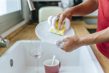 Man washing dishes in sink