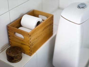 Toilet paper in crate on bathroom shelf