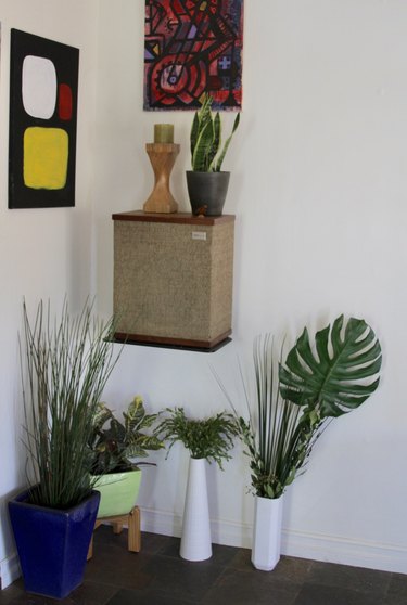 Faux plants in a room with artwork.