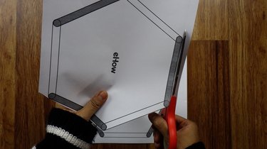 Cutting out templates to make popsicle stick hexagon shelves.
