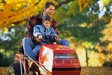 Father and son on tractor mower