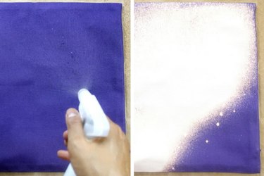Spraying bleach onto purple cushion cover.