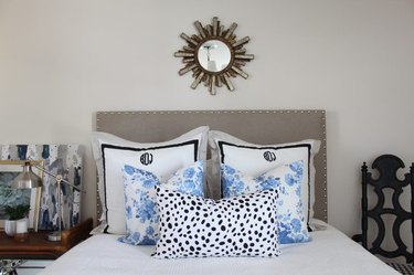 Bed with pillows and a gray padded headboard