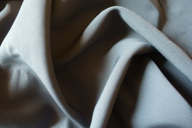 Background - simple dark gray viscose and polyester fabric in soft folds
