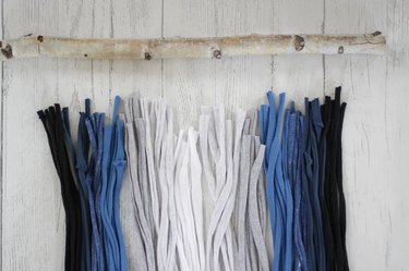 Grab some old t-shirts hanging around in your closet to create an eye-catching and stylish wall hanging.