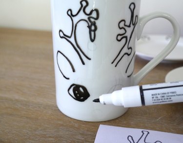 A porcelain pen tracing over the image on the mug