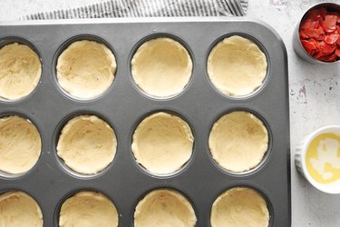 Press dough into muffin cups