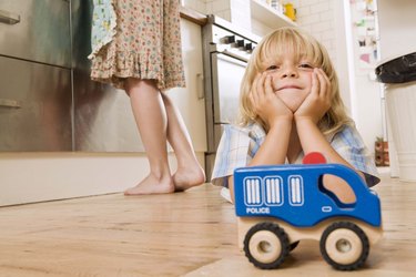 Boy on kitchen floor with toy car