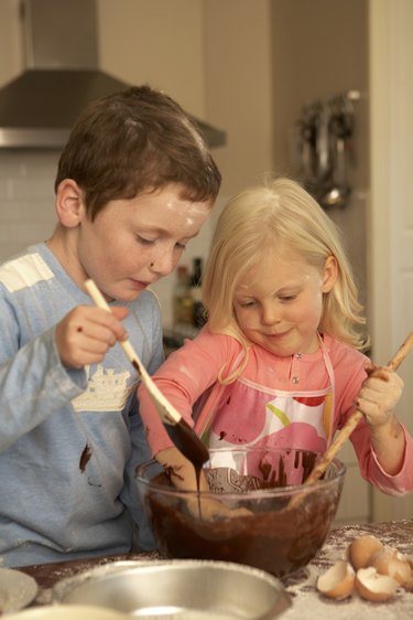 Sister and brother (4-5,8-9) baking in kitchen