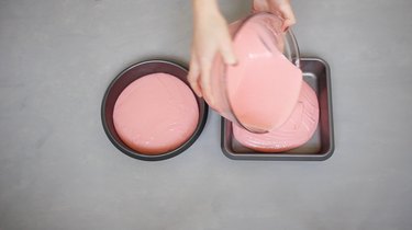 Pouring cake batter into two pans