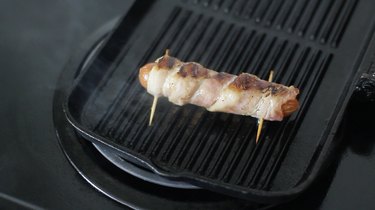 Grilling bacon-wrapped hot dog