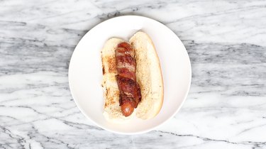 Bacon-wrapped hot dog in toasted side slit bun