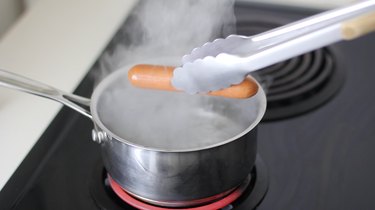 Placing hot dog in boiling water