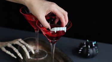 Garnishing drink with fake vampire fangs