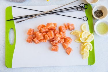 Chopped salmon and sliced lemon on a cutting board