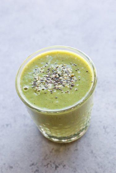 A glass of smoothie with chia and hemp seeds on top