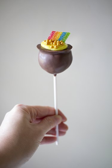 Person holding chocolate pot of gold cake pop