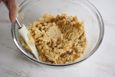 Stirring frosting into cake crumbs to form batter