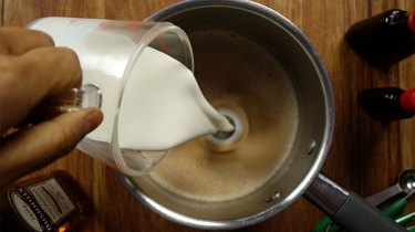 Adding half & half into saucepan for sugar-free Irish cream liqueur.