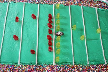 22 gummy bears arranged on football field cake with candy football