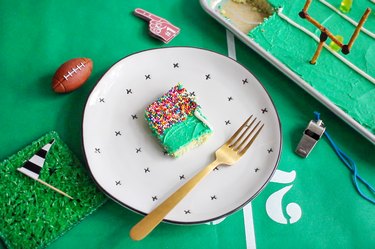 Slice of stadium sheet pan cake on plate with a gold fork