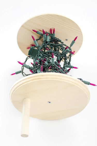 Organize your holiday decorations with a wooden spool.