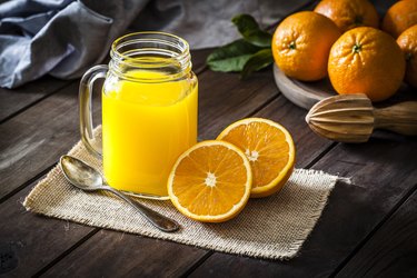 Orange juice glass jar shot on rustic wooden table