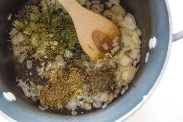 onion, garlic, and herbs in a stock pot