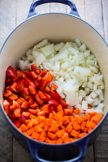 In a soup pot combine onions, carrots, and red bell peppers.