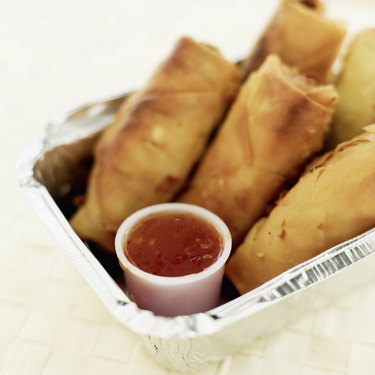 Close-up of spring rolls and sauce in a box